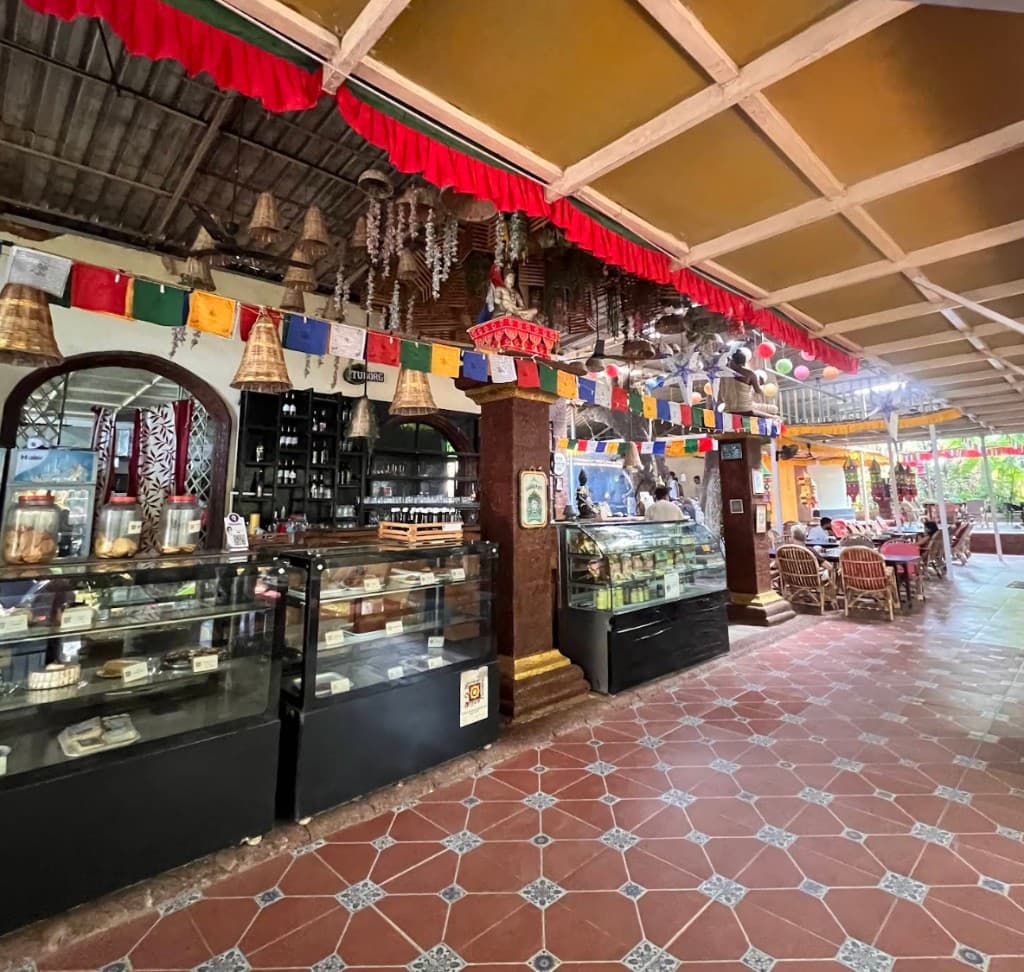 Display counters with bread, cakes, and jars inside German Bakery, Anjuna